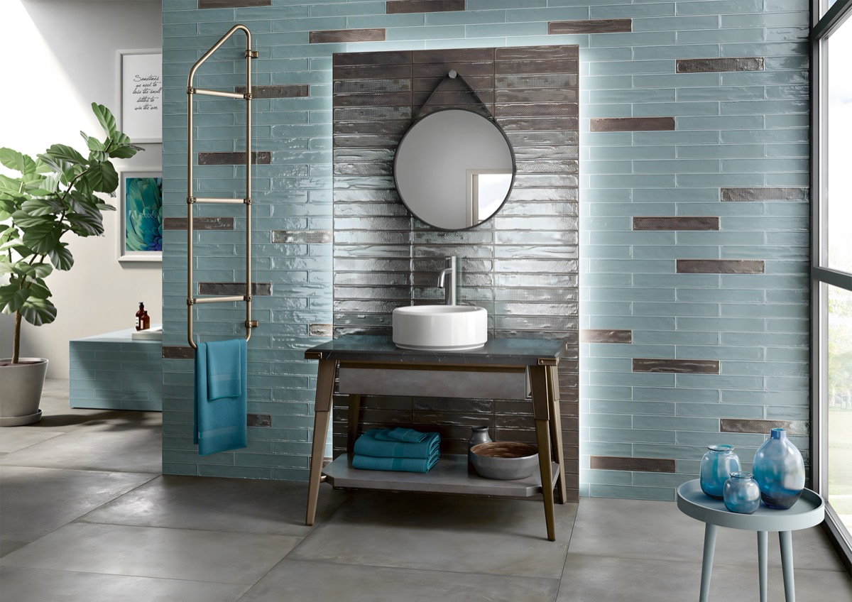 Bagno con rivestimento in ceramica lucida color petrolio e mobile sospeso