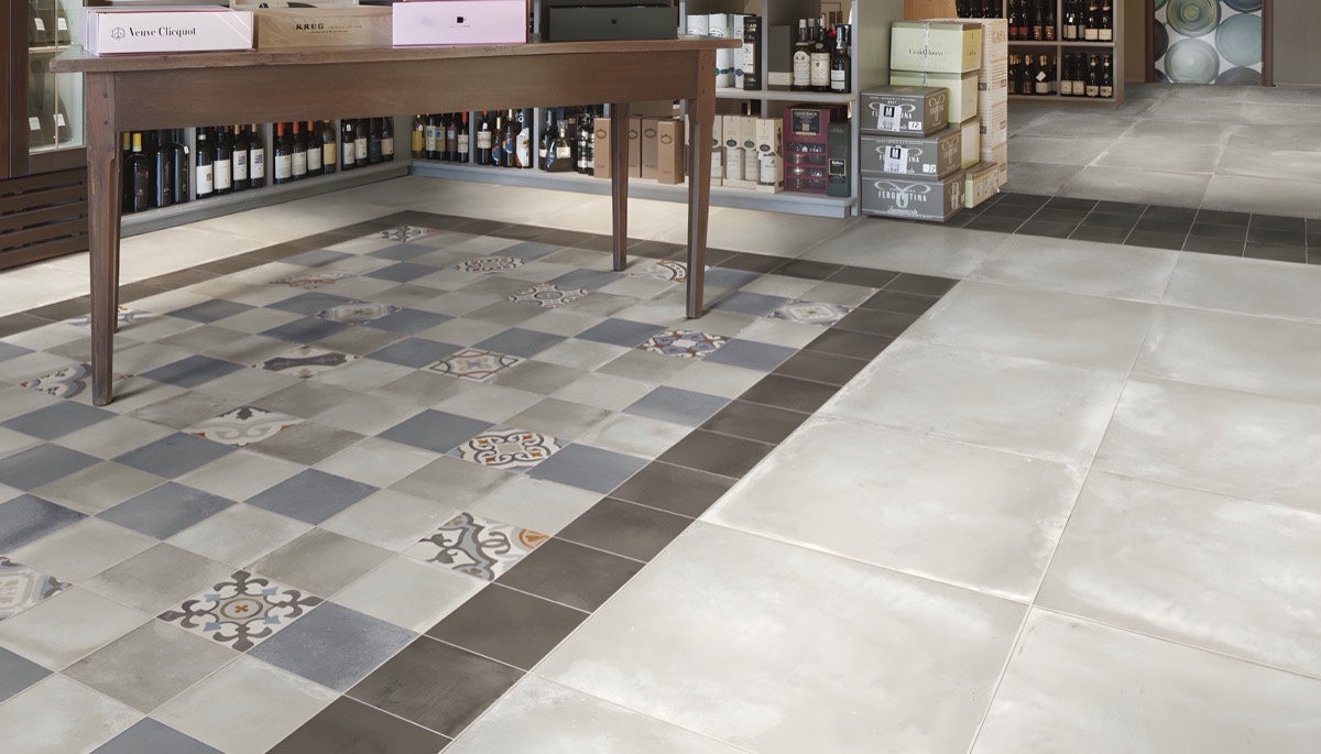 Pavimento in gres con fascia decorativa a scacchi in uno spazio commerciale